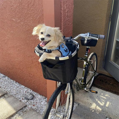Panier de vélo pour chien noir avec petit chien crème, monté à l’avant du vélo