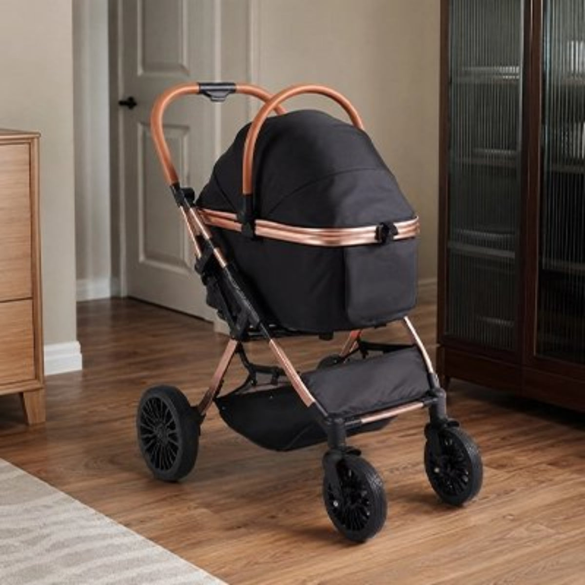 Poussette pour chien noire pliable, capote souple et cadre couleur cuivre, quatre roues.